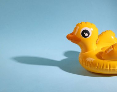 Mavi arka planda gölgesi olan şişme ördek. Asgari yaz düzeni