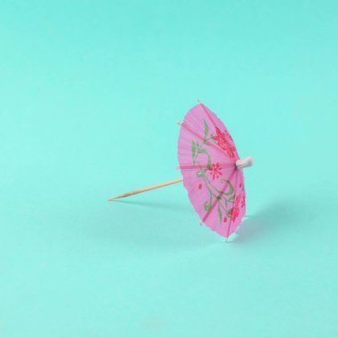 Mavi arka planda kokteyl şemsiyesi. En küçük yerleşim