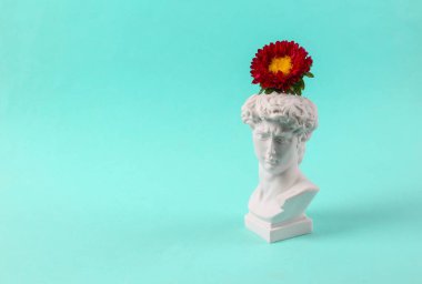 David 'in mavi arka planda çiçekli alçı büstü. Minimum yerleşim. Narsisizm