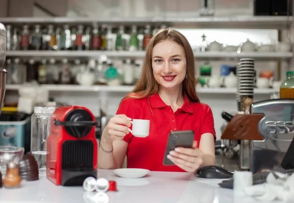 Mujer Barista Bebe Café Utiliza Smartphone Trabajo —  Fotos de Stock