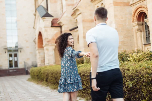 Follow Young Woman Pulls Young Guy While Walking Background Old — Stok fotoğraf