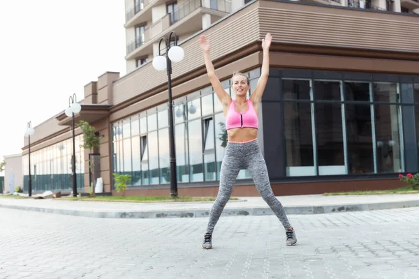 Açık havada zıplama pratiği yapan zinde bir kadın.