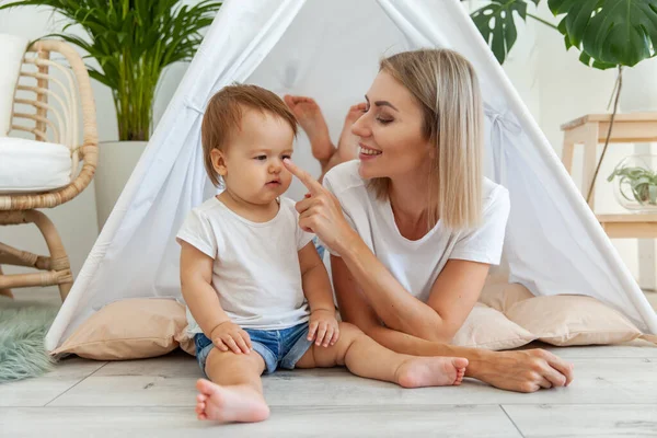 Genç anne ve küçük kızı evdeki bir çadırda birlikte vakit geçiriyorlar.