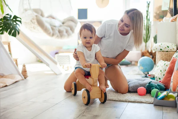 Anne ve küçük kızı oyun odasında vakit geçiriyorlar. Tahta scooterlı küçük bir kız. Anne bakımı, aşk konsepti