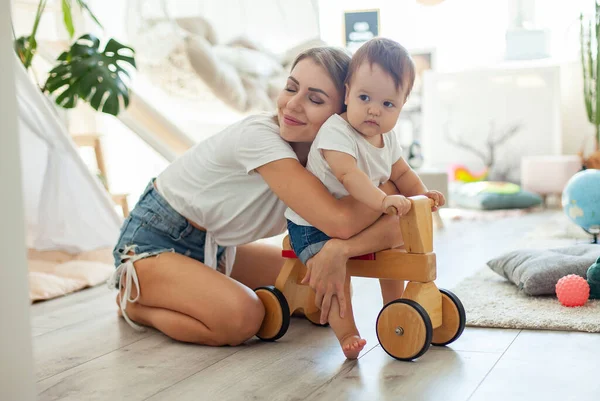 Anne ve küçük kızı oyun odasında vakit geçiriyorlar. Tahta scooterlı küçük bir kız. Anne bakımı, aşk konsepti