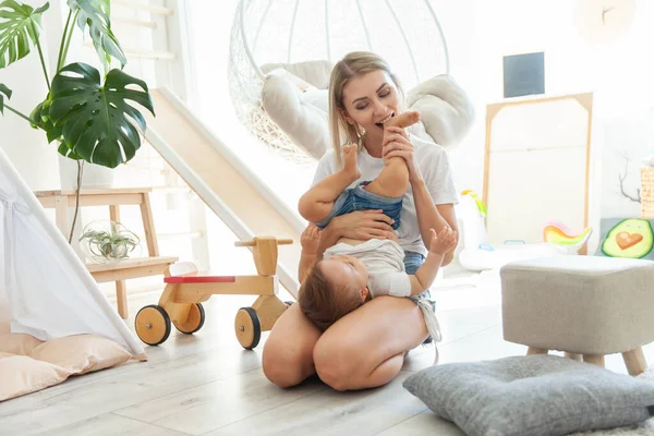 Küçük kızıyla birlikte sevimli genç bir anne oyun odasında oynuyor. Anne bakımı ve sevgi