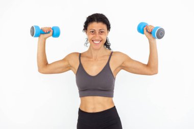 Beyaz arka planda izole haldeki halterli gülümseyen atletik kadın görüntüsü
