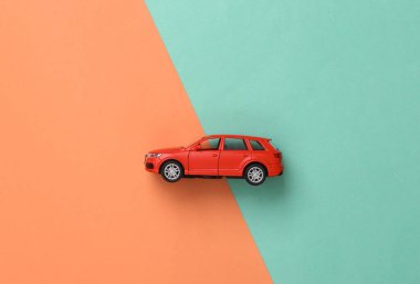 Mavi-pembe arka planda oyuncak bir araba. Üst Manzara. Düz yatıyordu