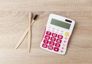 Tahta masadaki hesap makineli eko bambu diş fırçaları.