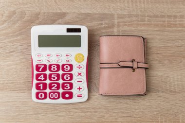 Tahta masada hesap makinesi olan deri çanta.