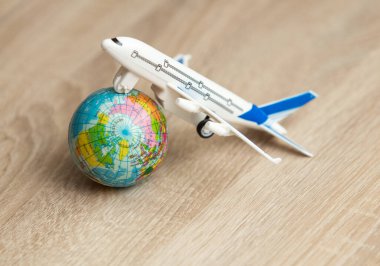 Tahta masasında küre olan bir yolcu uçağının oyuncak modeli.