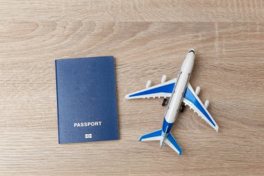 Ahşap masada pasaportu olan yolcu uçağının oyuncak modeli.