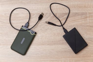 Tahta bir masada kablolu iki harici sabit disk.