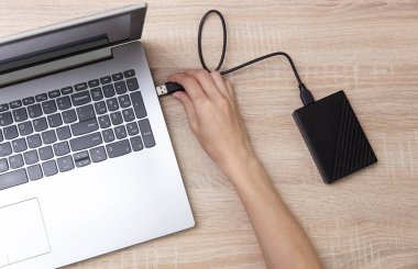 Kadın eli harici sabit diski laptopa bağlıyor