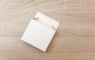 Tahta masadaki boş beyaz kutu. Üst görünüm