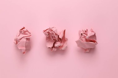 Pembe arka planda buruşmuş kağıt toplar