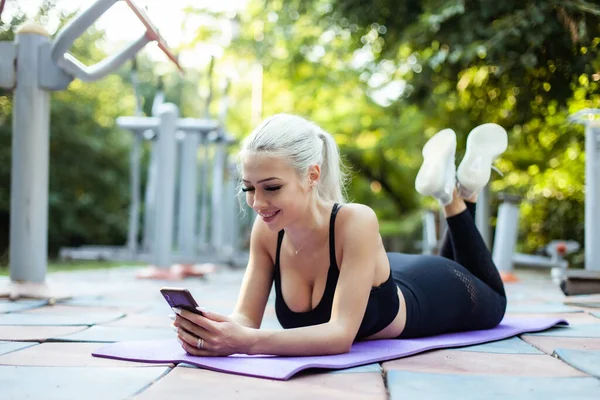 Fitness Vrouw Met Smartphone Terwijl Mat Het Sportveld Ligt — Stockfoto