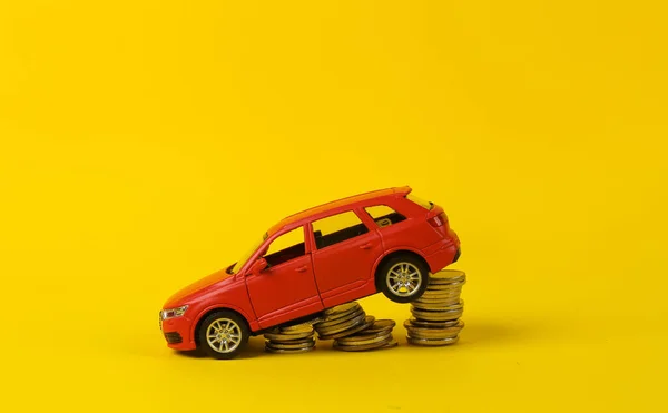 Brinquedo Modelo Carro Vermelho Com Uma Pilha Moedas Fundo Amarelo — Fotografia de Stock