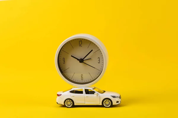 Zabawkowy Model Samochodu Zegarem Żółtym Tle — Zdjęcie stockowe