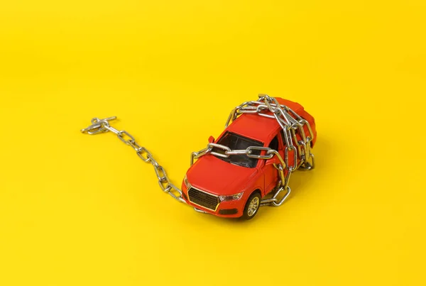Modelo Carro Brinquedo Rebobinado Por Uma Corrente Aço Fundo Amarelo — Fotografia de Stock