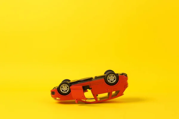 Kopfüber Liegendes Modell Eines Spielzeugautos Auf Gelbem Hintergrund Autounfall — Stockfoto