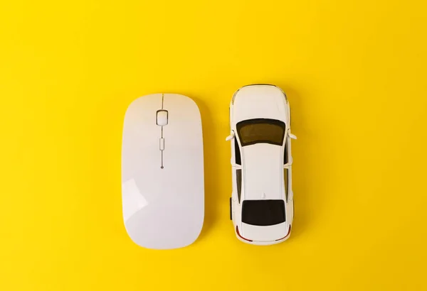 Toy car model with pc mouse on yellow background