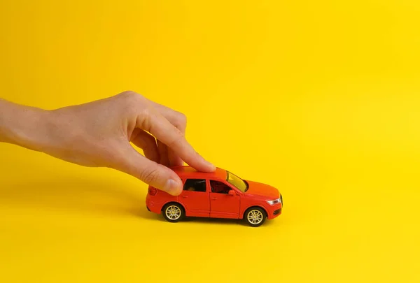 Mão Mulher Segurando Carro Brinquedo Fundo Amarelo Proteção Seguro Auto — Fotografia de Stock