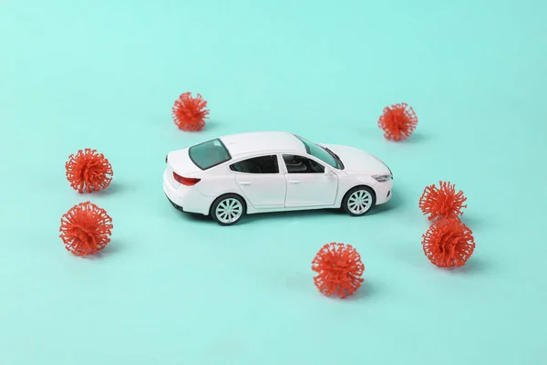 Toy car model with a virus strain on blue background. Protect your health concept