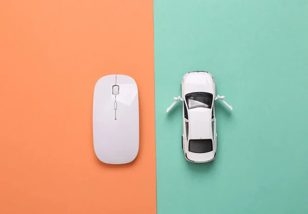 Toy model auto and pc mouse on a colored background. Online car order