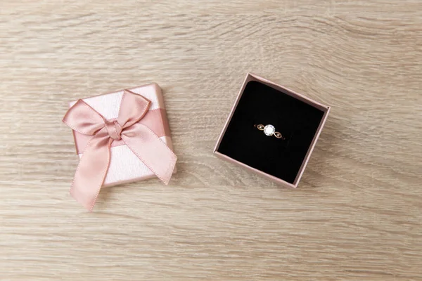 Gift box with gold ring with diamond on the table