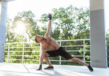 Çıplak gövdesiyle dışarıda egzersiz yapan atletik bir adam. Sağlıklı yaşam tarzı