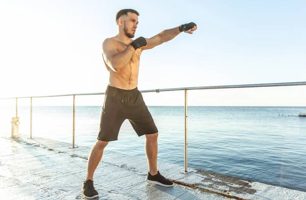 Athletic Man Training Kicks Early Morning Beach — ストック写真