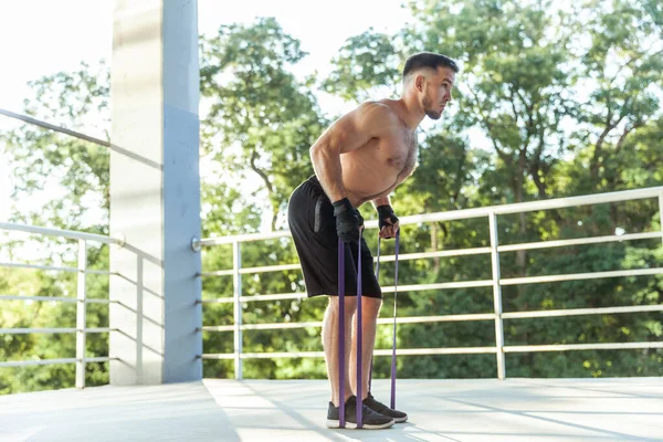 Sportowiec Trenuje Mięśnie Gumkami Fitness Świeżym Powietrzu Muskularny Mężczyzna Nagim — Zdjęcie stockowe