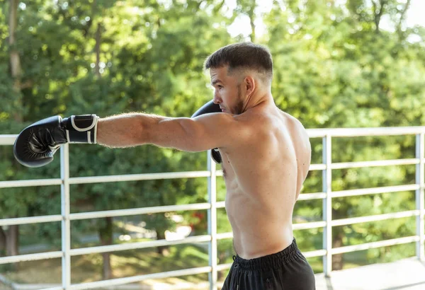 Muskularne Ciosy Treningowe Człowieka Rękawicami Bokserskimi Zewnątrz — Zdjęcie stockowe