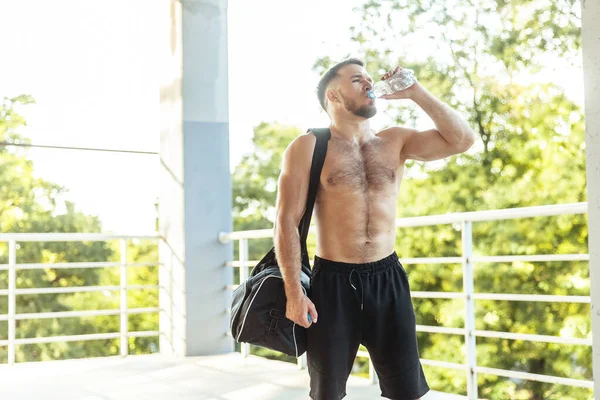 Fitness Man Exercise Bag Drinks Water Bottle Outdoors — Zdjęcie stockowe