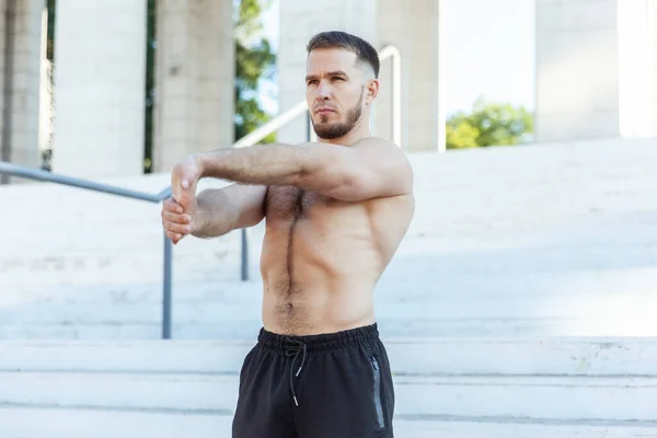 Young Male Athlete Naked Torso Kneads Muscles Doing Stretching Exercise — Stock Photo, Image