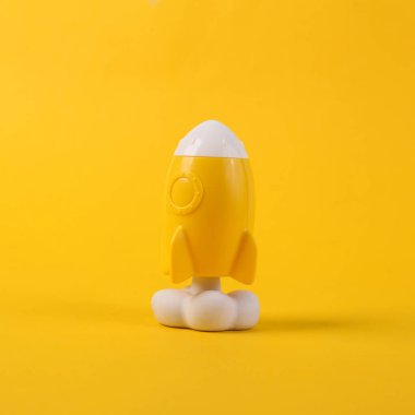 Oyuncak sarı uzay mekiği ya da sarı arka planda roket. Minimalizm, kavramsal pop, yeni fikir veya başlangıç