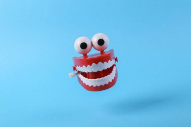 Mavi arka planda, gölgeli, saat gibi işleyen çene. Minimalizm hala hayat