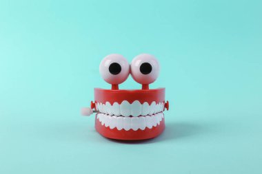 Turkuaz arka planda saat gibi çalışan çene. Asgari eğlence konsepti