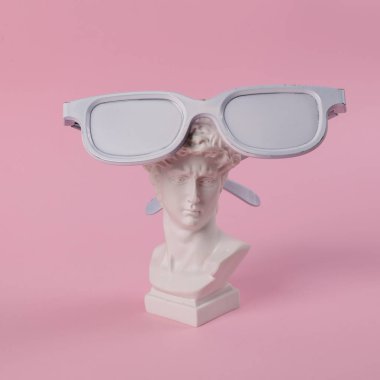 David 'in pembe arka planda beyaz gözlüklü antika büstü. Kavramsal patlama. Asgari güzellik ve moda hayattır. Yaratıcı fikir