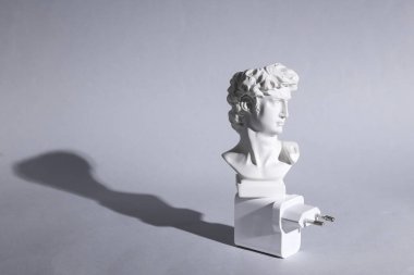 David 'in gri arka planda uzun gölgeli şarj cihazlı büstü. En az yaşam süresi