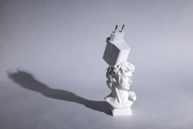 David 'in gri arka planda uzun gölgeli şarj cihazlı büstü. En az yaşam süresi