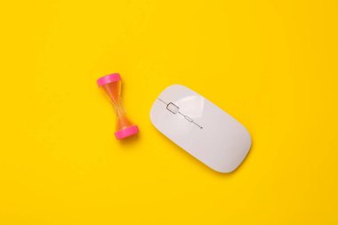 Sarı arka planda kum saati olan bilgisayar faresi. Üst görünüm