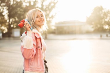 Genç havalı hippi kız. Kaykayla şehirde vakit geçiriyor.