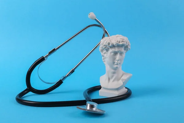 Stetoscopio Con Busto Antico David Sfondo Blu Composizione Medica Natura — Foto Stock