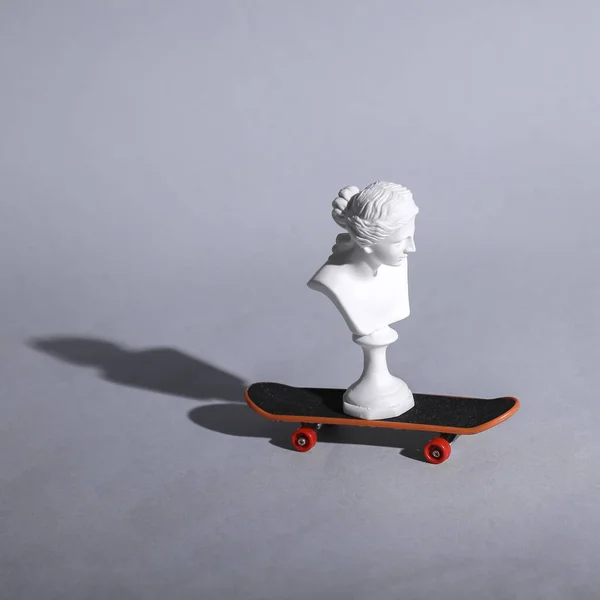 Venusbüste Auf Einem Skateboard Grauer Hintergrund Minimales Stillleben — Stockfoto