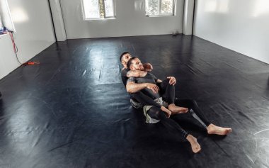 İki atletik erkek boksör spor salonunda acı verici bir şekilde antrenman yapıyorlar..