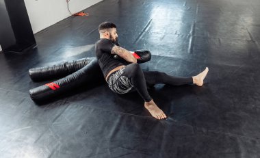 Sporcu erkek güreşçi spor salonunda mankenle tutunuyor.