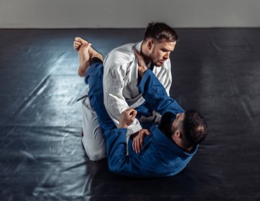 Kimonolu bir eşle antrenman yapan iki boksör spor salonunda acı dolu duruşmalar yapıyor.