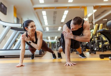 Athletic man and woman training together in the gym